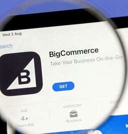 magnifying glass held over laptop screen showing BigCommerce on the app store