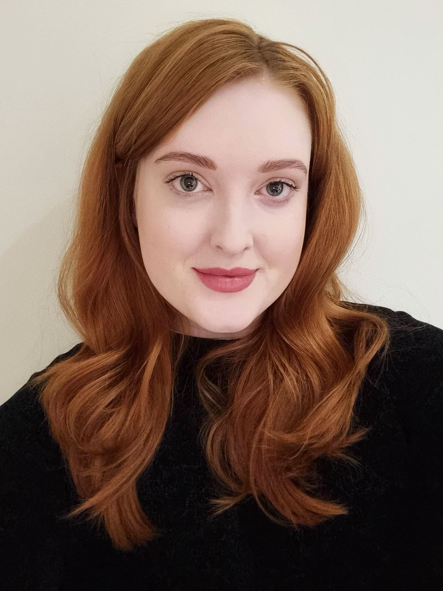 portrait headshot of a red-haired woman with a black top