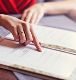 Hand pointing to a printed restaurant menu