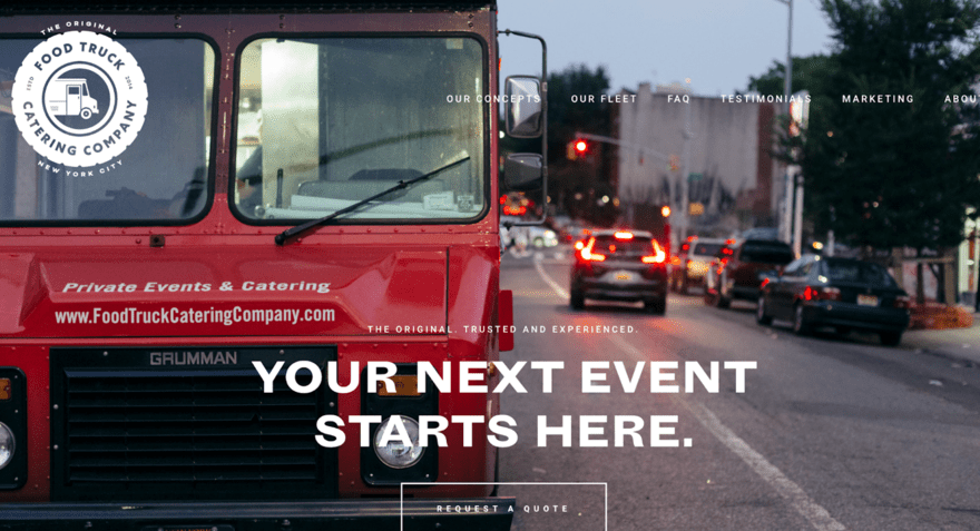 A big red food truck with traffic driving in the background.