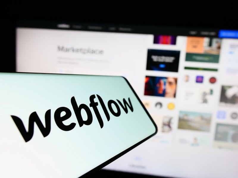 webflow logo with computer screen out of focus in background