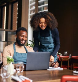 Restaurant managers working with laptop