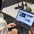 Woman in white shirt browsing her website content on a laptop in an office setting