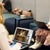 Two women using laptops in a modern office lounge area - one is watching an online service on YouTube.