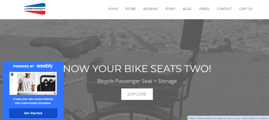 Webpage header for a bike accessory company, featuring a bike seat for two with the slogan "Now Your Bike Seats Two!" and a call-to-action button labelled "Explore".