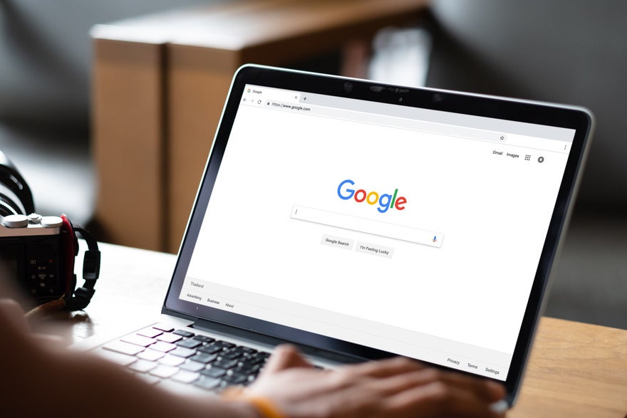 Person working on a laptop with the Google homepage displayed on screen