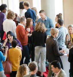 Event space full of a crowd of people networking and talking