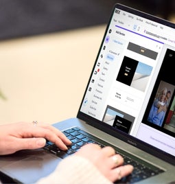 A professional woman working intently on building a website on her laptop.