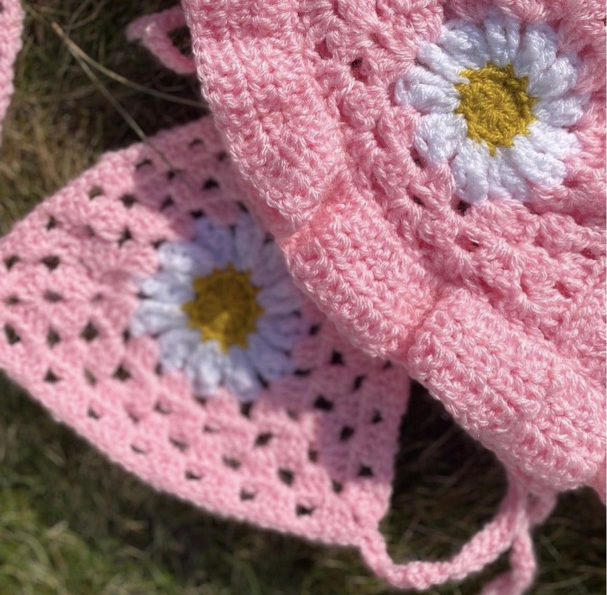 Pink crochet clothing with white and yellow flower pattern