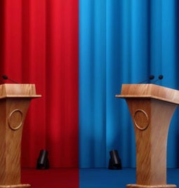 Photo of curtains with a red and blue side and podiums at each end